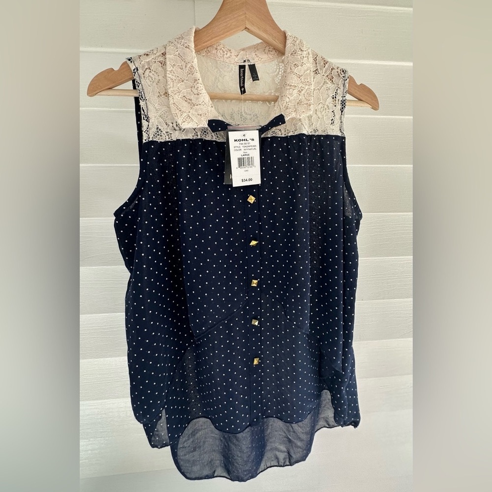 Flowy lace and sheer top with gold accent buttons. Cream and navy polka dot.